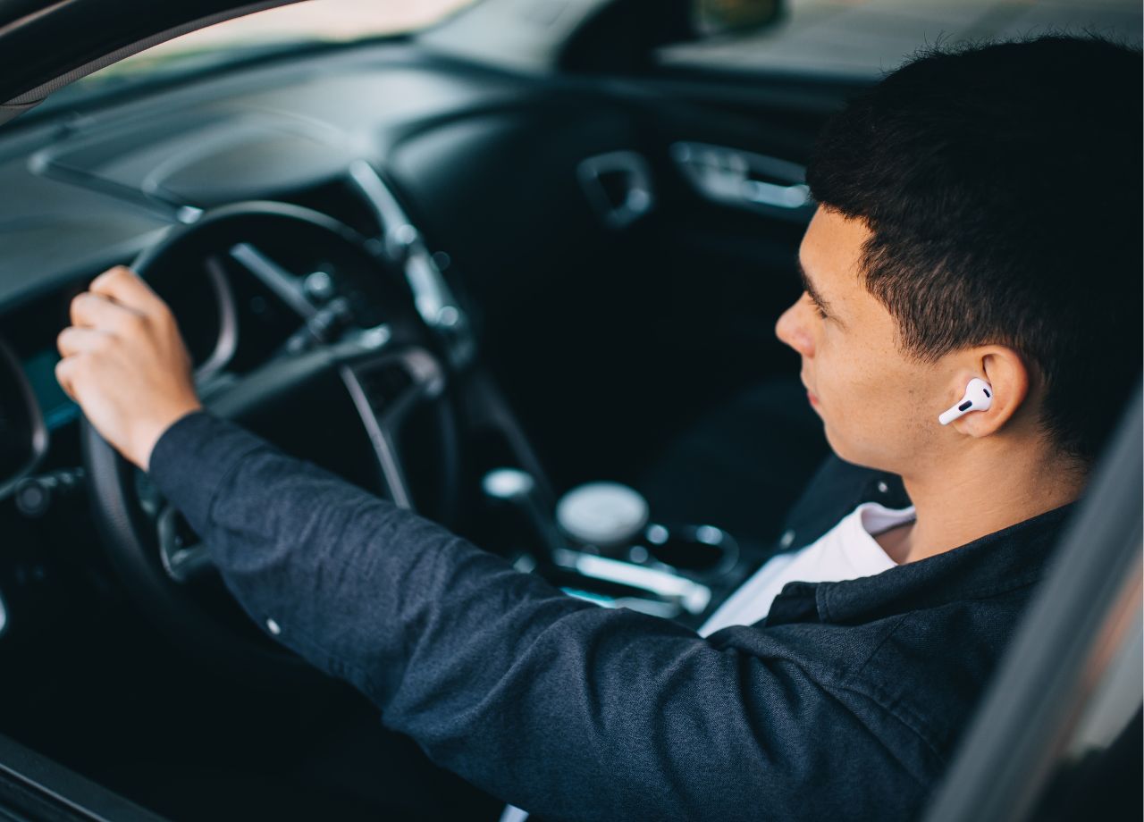 „Ohren auf!“ – Sind Kopfhörer im Straßenverkehr erlaubt? - Mann mit Kopfhörern im Auto