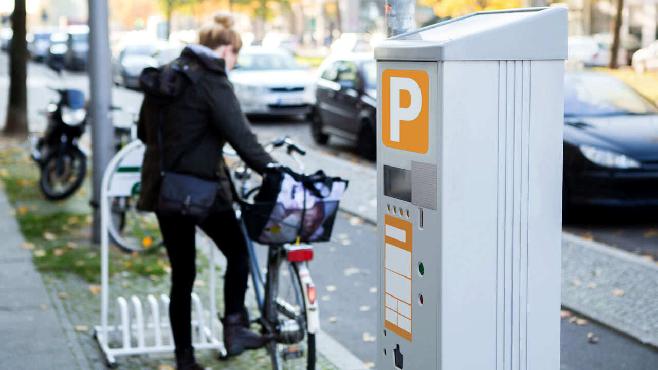 Frau stell ihr Fahrrad noch nicht auf dem Autoparkplatz ab. Das wird sich in Berlin ab 2023 ändern.