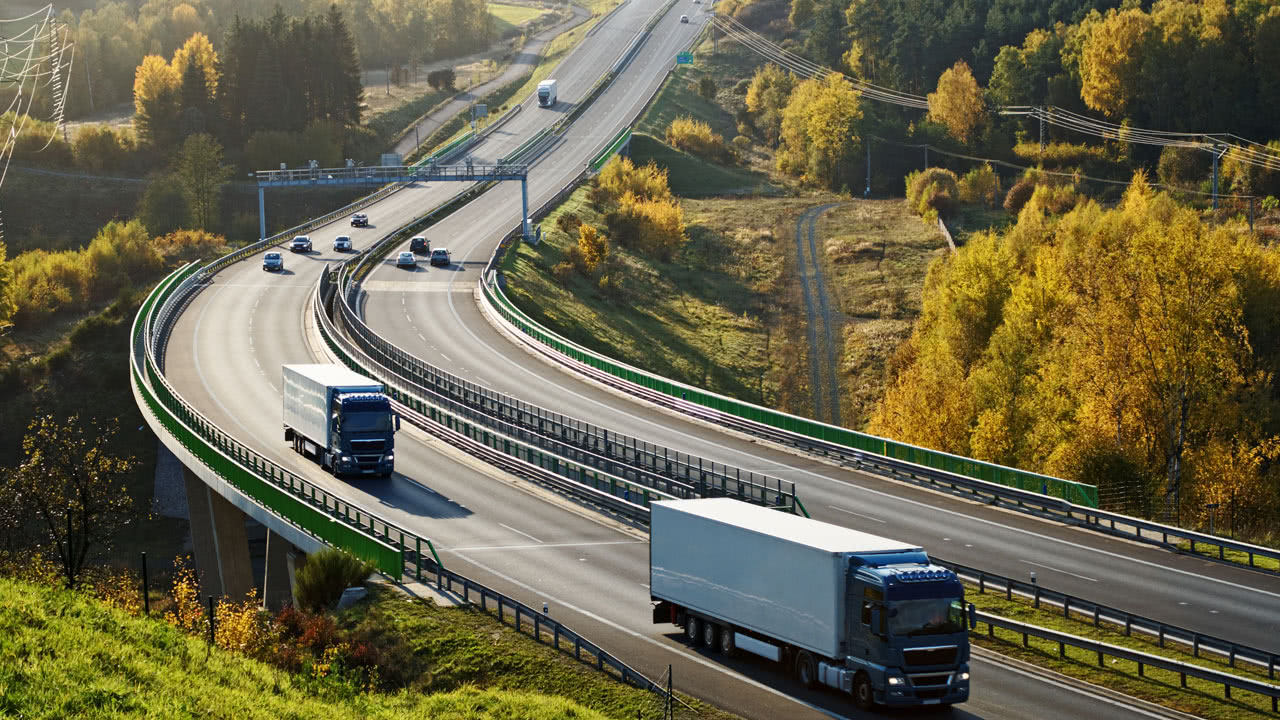 LKW fährt auf der Autobahn an einer Mautstelle vorbei. Im Jahr 2023 sollen die Gebühren steigen.