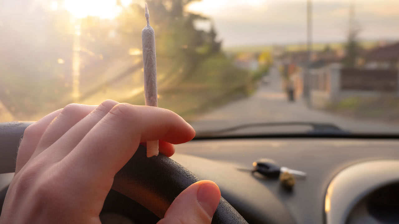 Autofahrer raucht Cannabis beim Autofahren.