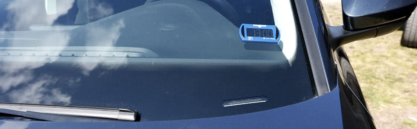 Elektronische Parkscheibe in einer Windschutzscheibe von einem Fahrzeug.
