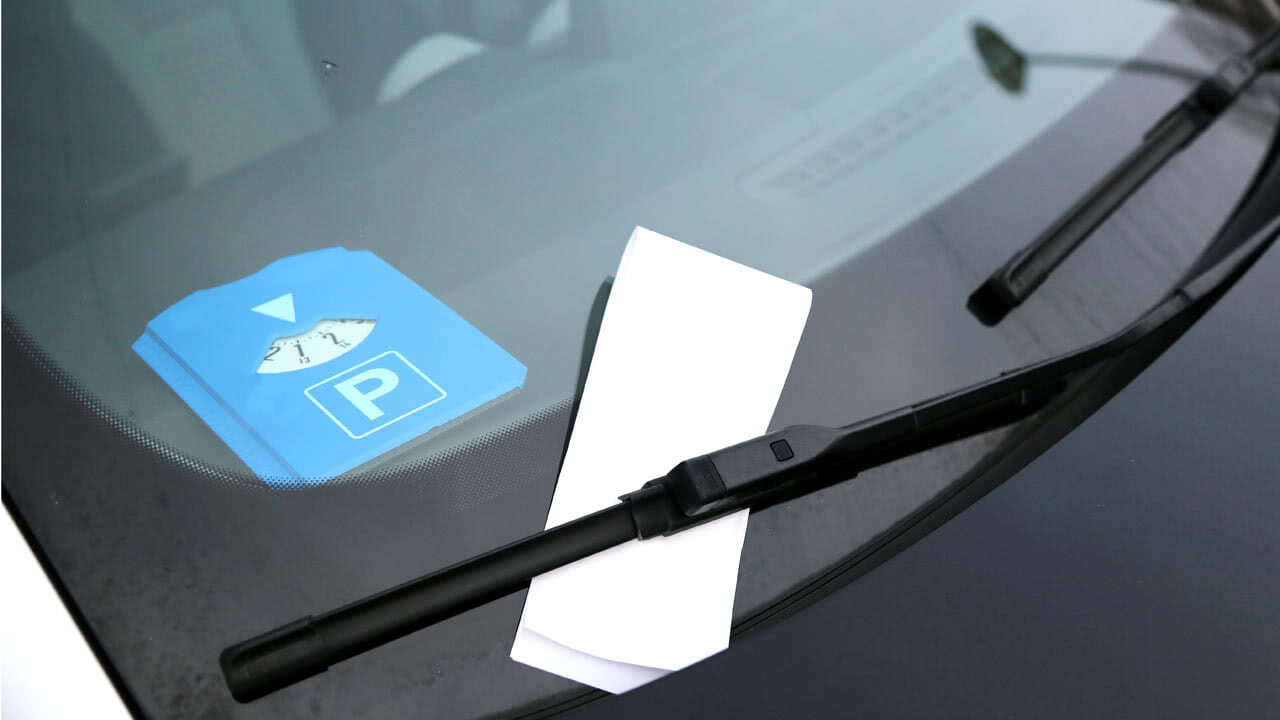 An einem parkenden Fahrzeug ist ein Knöllchen aus Gemering angebracht, da die Parkscheibe falsche Ziffern abgebildet hat.