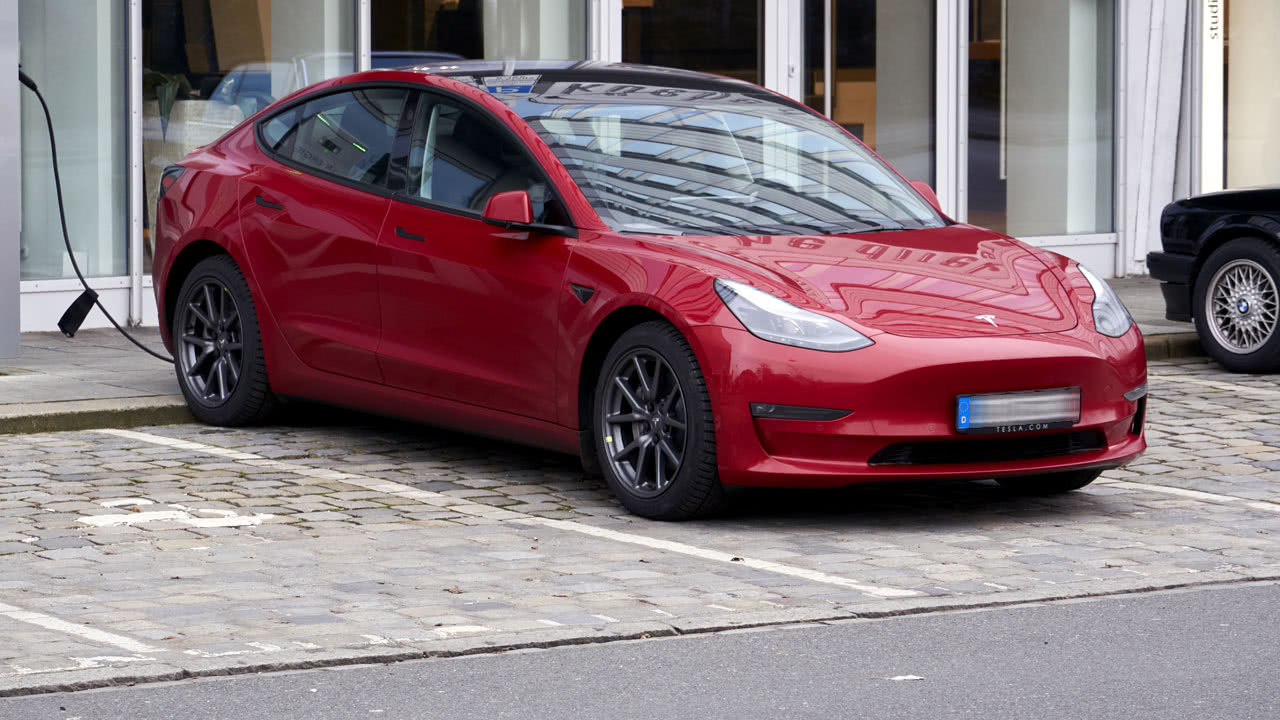 Tesla wird auf einem Parkplatz mit dem Supercharger aufgeladen