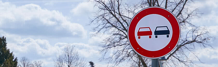Ein Verkehrsschild das am Fahrbahnrand den Überholvorgang für Kraftfahrzeuge verbietet