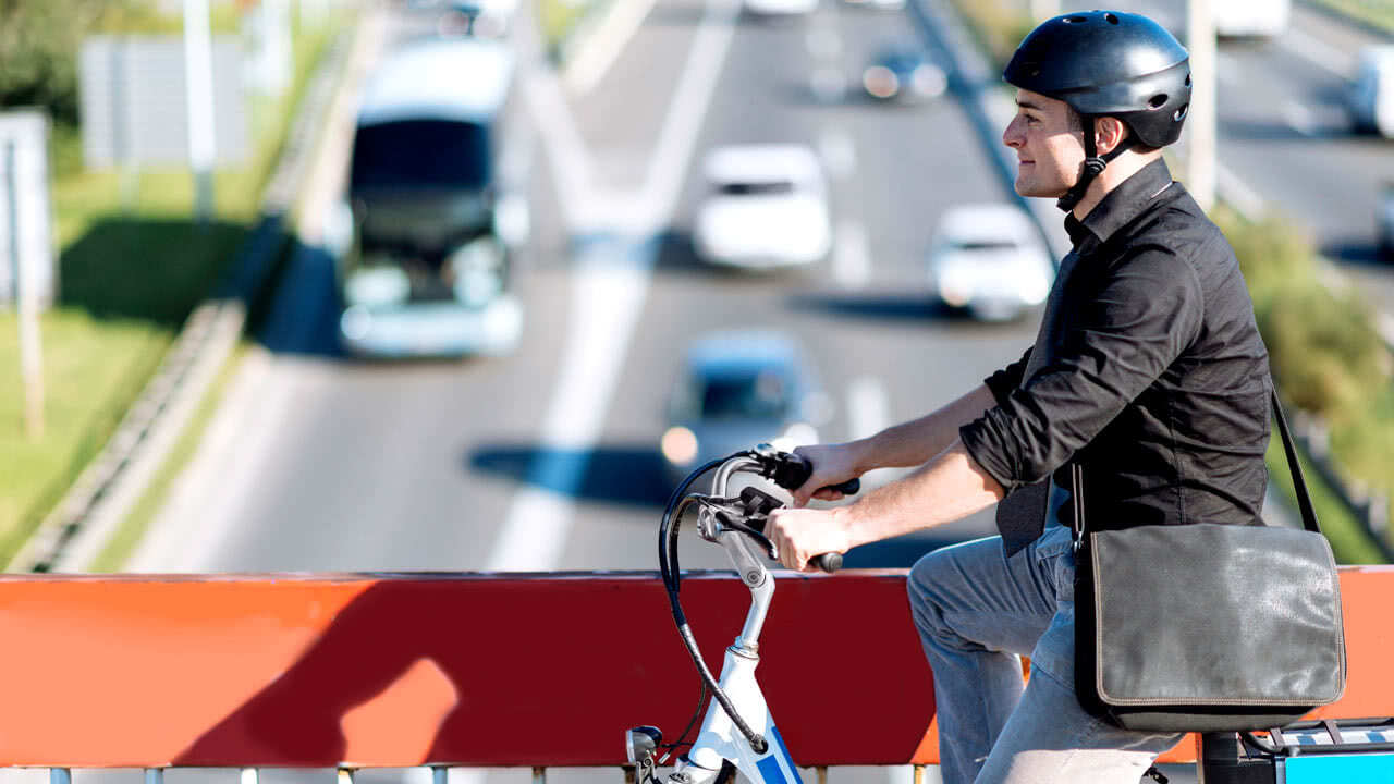 Fahrradfahrer fährt über eine Autobahnbrücke. Ob bald Autobahn an Sonntagen autofrei werden sollen wird heiß diskutiert.